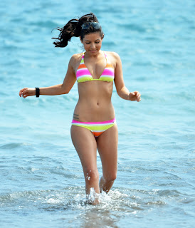 Roxanne Pallett running in the bright blue water in her colorful bikini