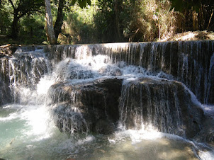 Water dropping through different stages of the hill-side at Kuang Si waterfalls.