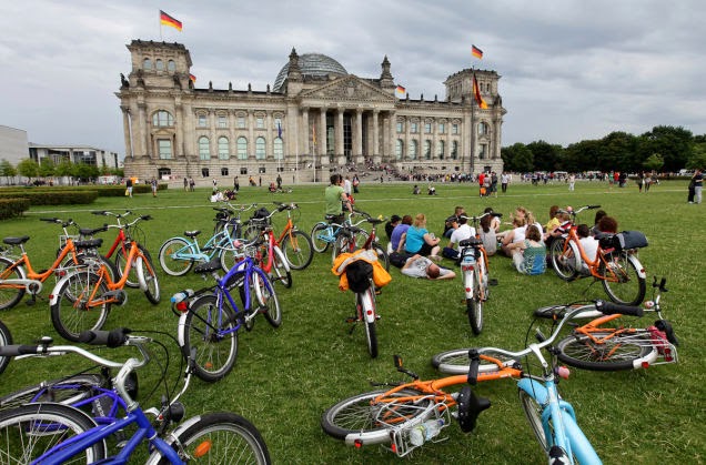 Tourists with rented bicycles lie on the grass in front of the Reichstag, the seat of the German Bundestag. Berlin is a bike friendly city, worth wandering around on bicycle. - 18 Amazing Places You Should Ride Your Bike Before You Die Tourists with rented bicycles lie on the grass in front of the Reichstag, the seat of the German Bundestag. Berlin is a bike friendly city, worth wandering around on bicycle. - 18 Amazing Places You Should Ride Your Bike Before You Die