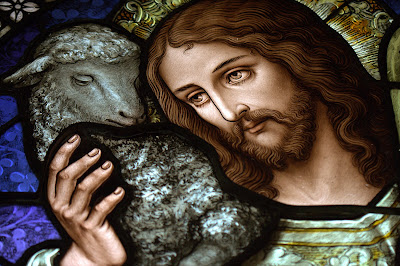 Stained glass window with close-up of Jesus the Good Shepherd with a lamb on his shoulder