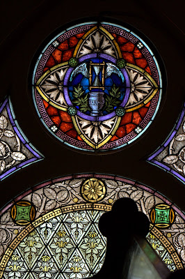 Stained glass window of hourglass with wings