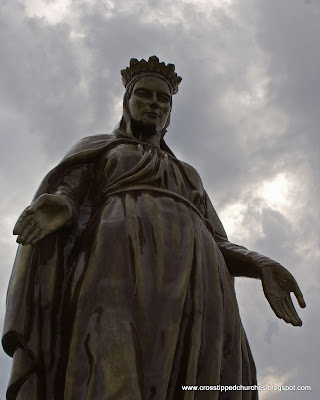 Large Statue of Our Lady of Ephesus with clouded sky background.
