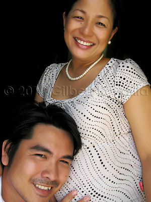 Dad leaning against mom's pregnant tummy