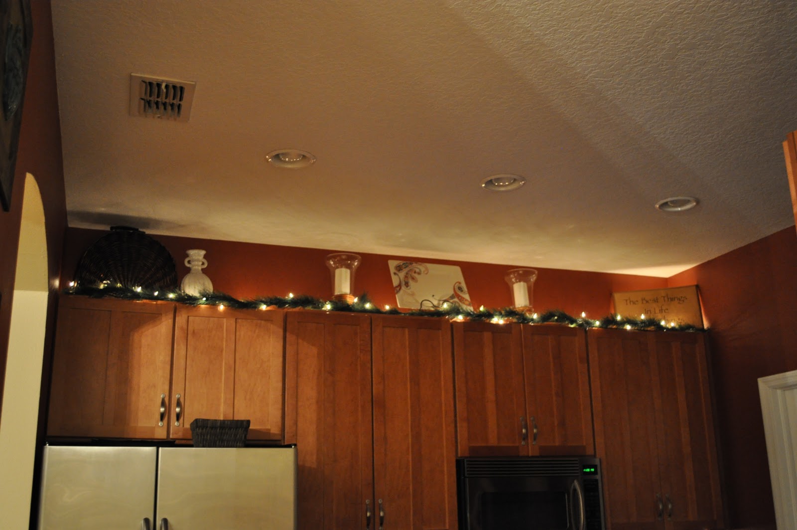 Holiday kitchen cabinets In the kitchen, I just added some lighted garland above the cabinets