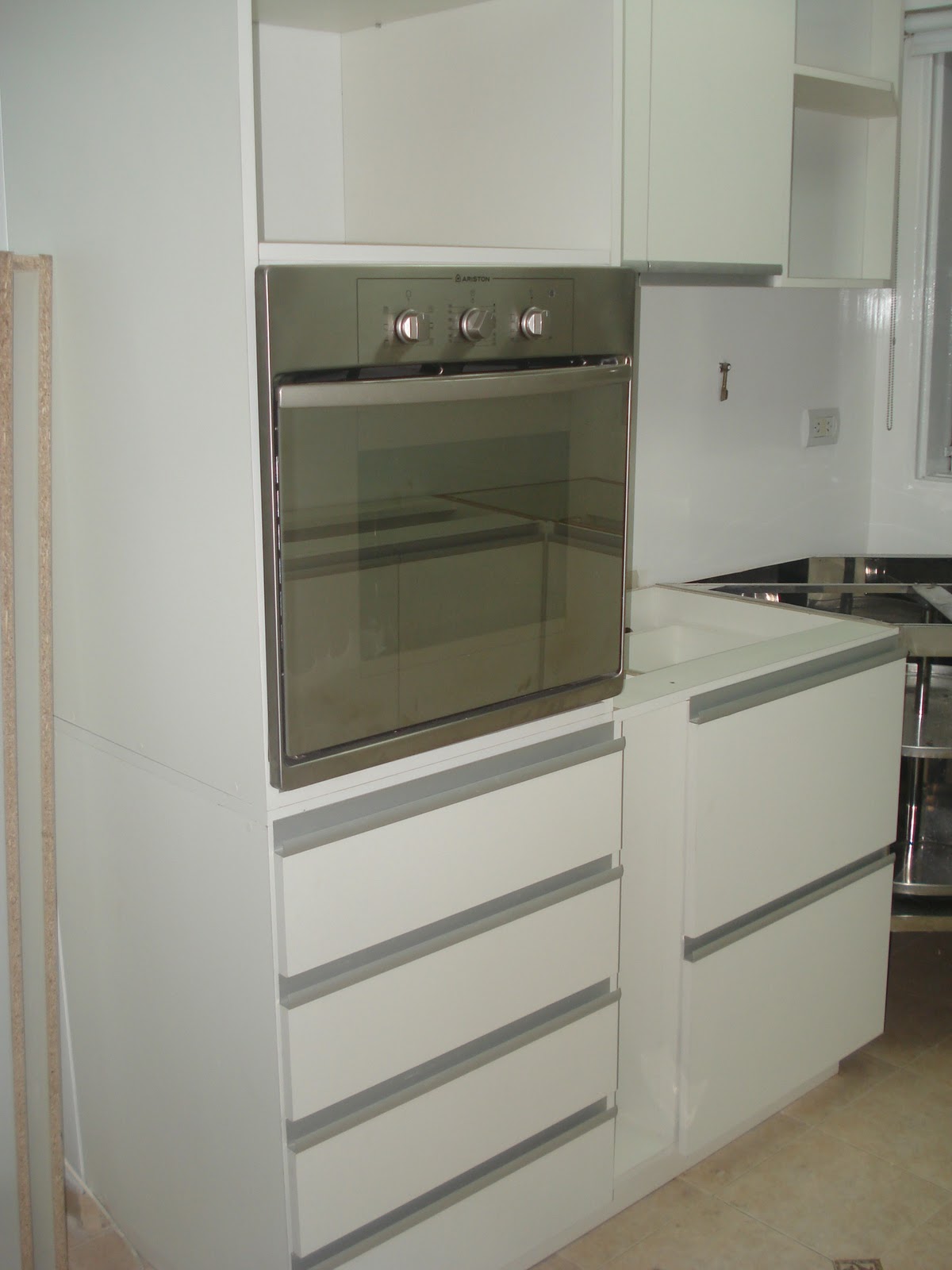 Cocina con terminaciones de melamina blanca y manijas de aluminio en Cocina con terminaciones de melamina blanca y manijas de aluminio en