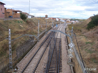 Entrada en la localidad de Sahagún sobre las vías del tren, con la torre de San Lorenzo al fondo