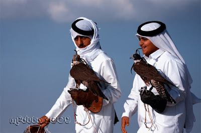 Two young arab men with their hawks.