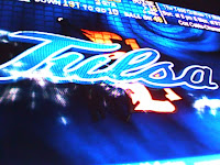 Blue computer graphic reading Tulsa in light blue against a black and blue background.
