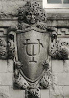 Close up view of a concrete decorative piece of art with a shield with the letters U and T overlapping.