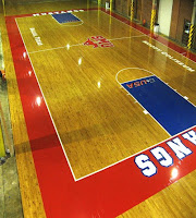 basketball court with red border and blue free throw lanes. Red baseline reads Mustangs in white letters.