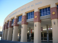 Brown columns with glass panes on a circular building with white letters reading The University of Texas at El Paso.