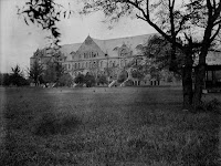 Black and white dated photograph of eighteenth century building in an otherwise deserted lawn.