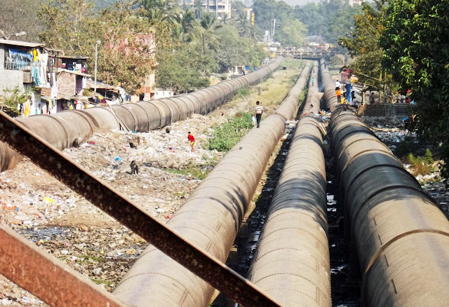 pipeline carrying water amidst garbage