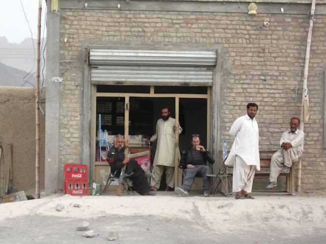 Taking a liquid roadside break. The policeman with the AK47 is part of our armed guard.