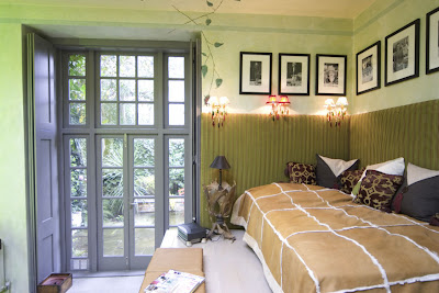 Grene bedroom in a London pied-a-terre with a lovely garden view and vine mural on the wall