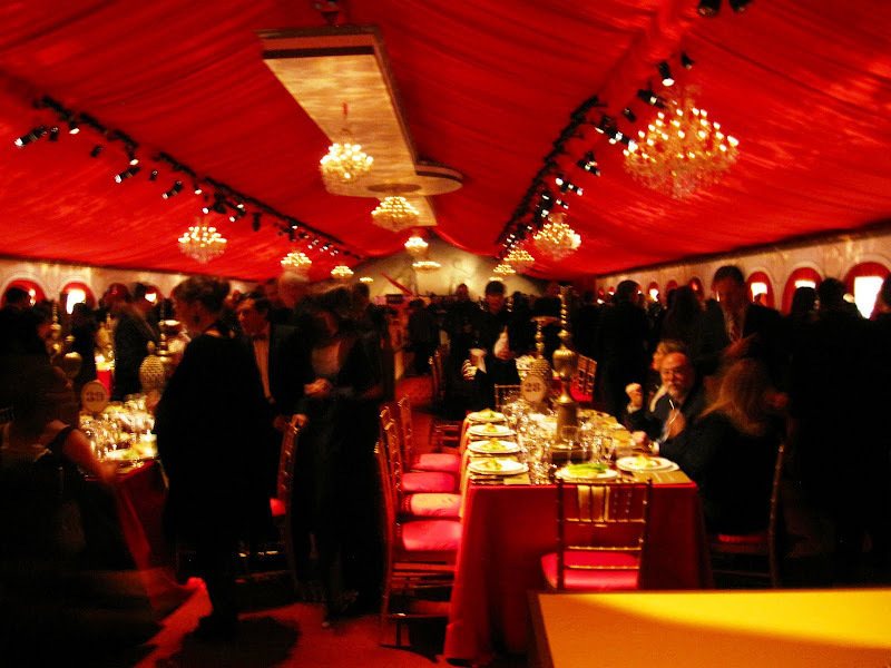 The tent was draped in red with large crystal chandeliers The tent was draped in red with large crystal chandeliers