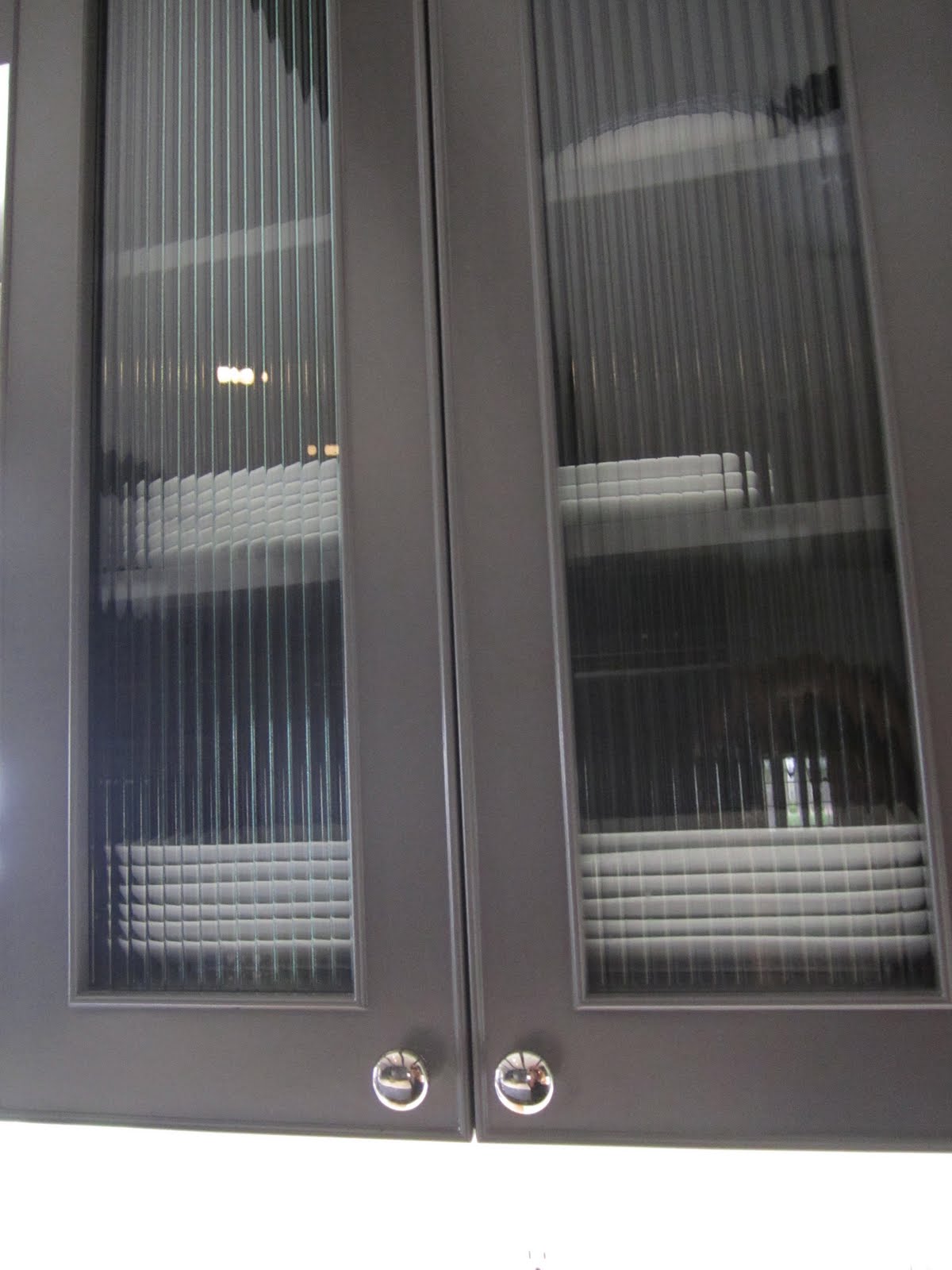Grey cabinet with reeded glass upper cabinet doors in a kitchen Grey cabinet with reeded glass upper cabinet doors in a kitchen