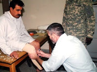 Chris Cummings, a prosthetist in the IA surgeon general's office prosthetics clinic in Baghdad, runs some tests on 1st Lt. Mohy Ali's limb during an initial visit on April 21. Mohy, an IA soldier, lost his foot during an IED attack on Jan. 10 while on a joint mission with Coalition forces. (U.S. Army photo by Sgt. 1st Class Tami Hillis)