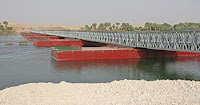 The newly constructed Baghdadi Bridge spans the Euphrates River, allowing local Iraqis and coalition forces to dramatically reduce the traveling time to reach the other side. Marines, Soldiers, Sailors and Iraqis worked together to complete the 301-meter bridge May 22, making it the longest floating bridge in Iraq. (U.S. Marine Corps photo by Lance Cpl. Robert Medina)