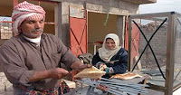 Hussen Jowd, a butcher in Arab Jabour, serves a sandwich at his newly renovated butcher shop and food stand. Jowd received microgrants that enabled him to increase his stock and expand his business. (U.S. Army photo by Sgt. Kevin Stabinsky)