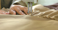 A woman in the Alemia sewing shop works on a sewing machine to create a new garment. (U.S. Army photo by Sgt. Kevin Stabinsky)