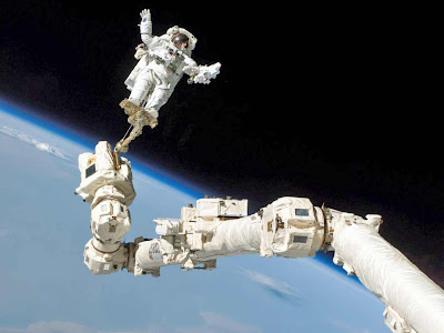Astronauta na ponta do braço mecânico da nave espacial - plano de fundo