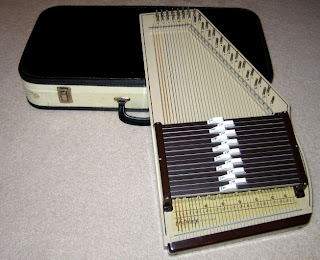 An autoharp. The image was taken from http://www.karlosthejackal.com/drowsy/gallery/