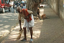 man sweeping road in India
