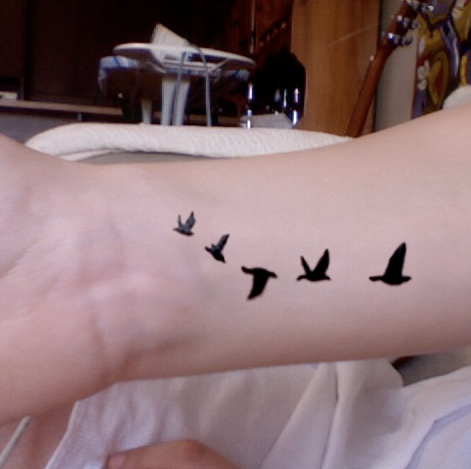 Tatouage bracelet lettre et chiffres romains sur le poignet d