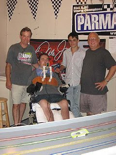 Image of Victor (Joe's Dad), Joey Jr. and Jeff looking on as Joe gets ready to take his first laps - using his adapted slot car / scalextric Controller.