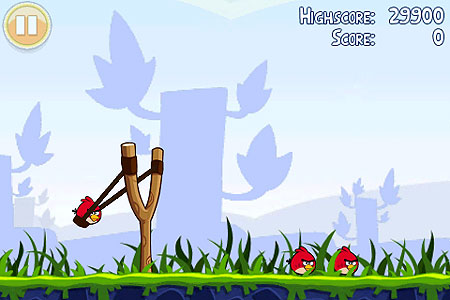 Image of Angry Birds, iOS game, where you sling shot a bird back to crash into pigs protected by flimsy structures.