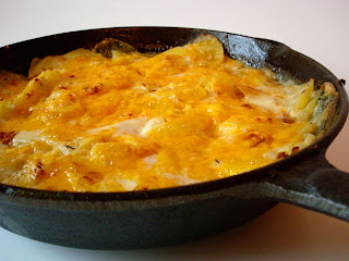 potatoes and cheese in a dark skillet