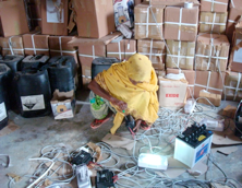 An engineer takes stalk of her equipment including light bulb and battery powered by solar energy.