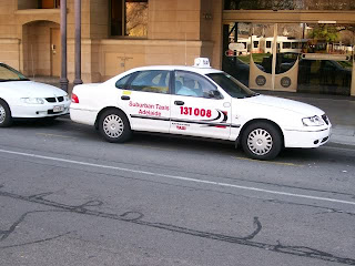 a white taxi cab parked on the side of a road