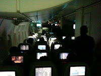 a group of people in an airplane with monitors