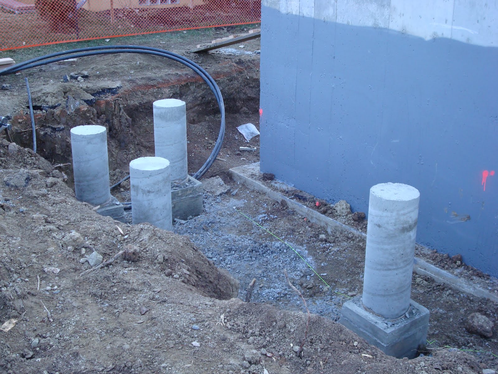 The Burgesses' New House: Concrete piers for front and rear decks are