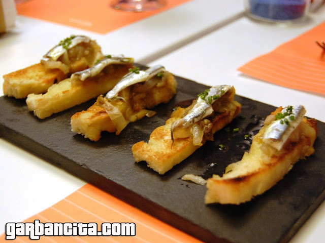 Tostada de escalibada con boquerones en vinagre en aceite