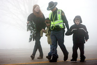 State Trooper L.C. Block, center right, holds the hands of Carter Raymond, far right, and his cousin Kyle Czarnik as Kyle's mother, Andrea Thorngren, holds her sons hand and they walk away from the crash scene on Interstate 90 Sunday.(Photo by Leah L. Jones - State Journal)