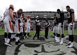 The Oakland Raiders and Cincinnati Bengals ready for a coin flip to determine possession in overtime