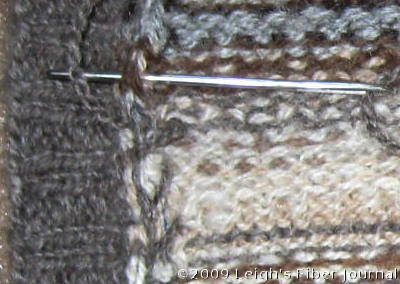 Tacking down the raw edge with cross-stitch. Tacking down the raw edge with cross-stitch.