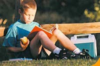 boy with book NAMC montessori reading aloud to children learning to read