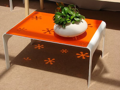 Hoc Die Design, mesa con flores naranjas reflejadas en el suelo