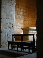 simple stone altar viewd through wooden benches