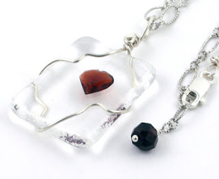 clear fused art glass with faceted garnet tack fused and wire wrapped to create a pendant