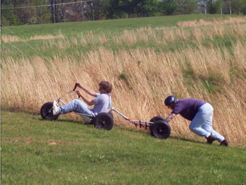 Tandem buggy being pushed up a hill