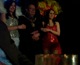 Belfast Lord Mayor Tom Hartley along about to be escorted on stage by two dancing girls at the launch of the tenth Cathedral Quarter Arts Festival