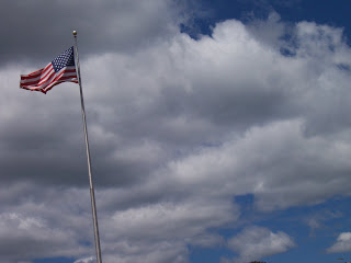 American flag with blue sky and clouds