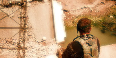 A British soldier of 9 Parachute Squadron Royal Engineers sits on a destroyed bridge abutment during a pause in the stripping out of a military bridge in the Rumaylah oilfields, Iraq