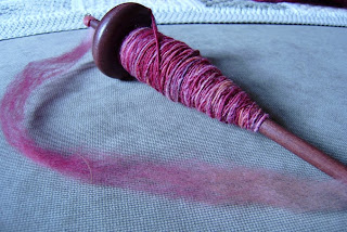drop spindle with my first proper hand spun yarn