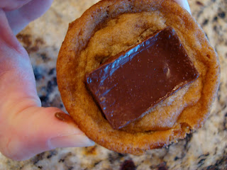 Hand holding one Non-Vegan Chocolate Chip Cookie with Dove Dark Chocolate Caramel Centers